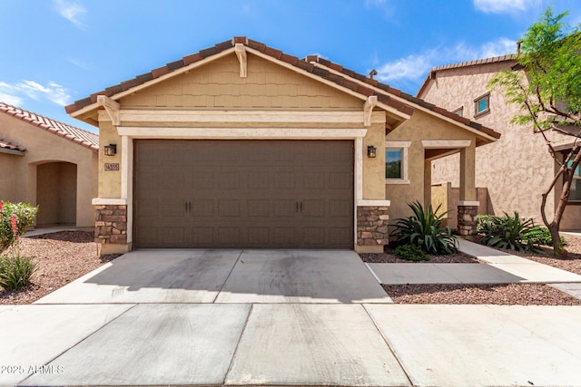 14355 W Valentine St, Surprise, AZ 85379 - view of front of house featuring concrete driveway, an attached garage, and stone siding