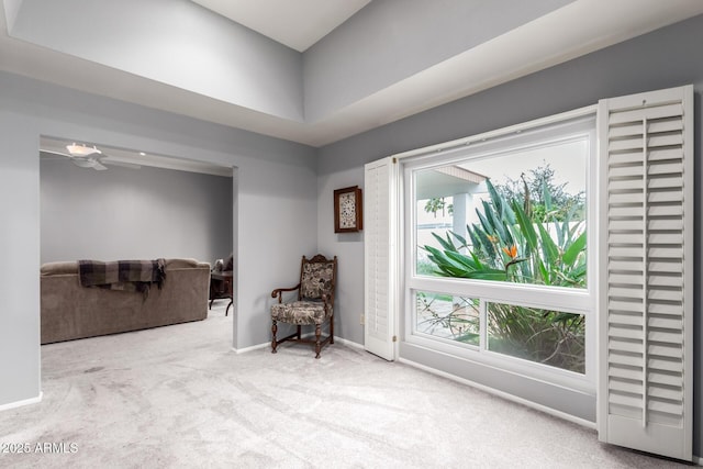 living area featuring carpet and baseboards