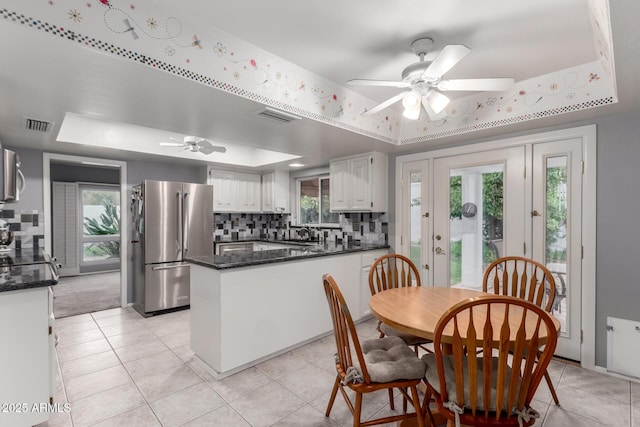 dining room featuring visible vents, a tray ceiling, and light tile patterned flooring