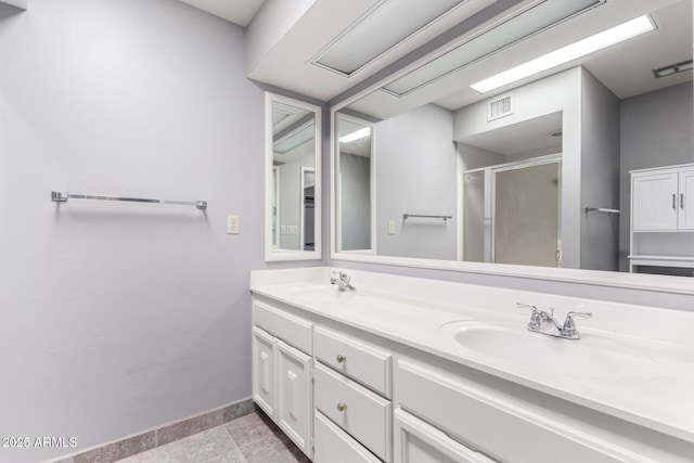 full bath with double vanity, a sink, visible vents, and a shower stall