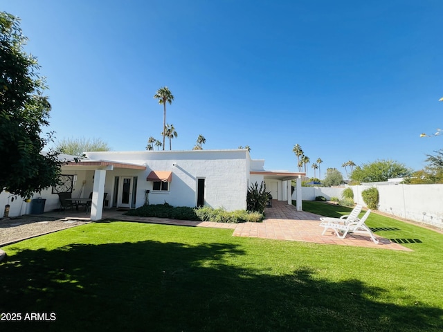 back of house featuring a yard, a patio area, fence, and stucco siding