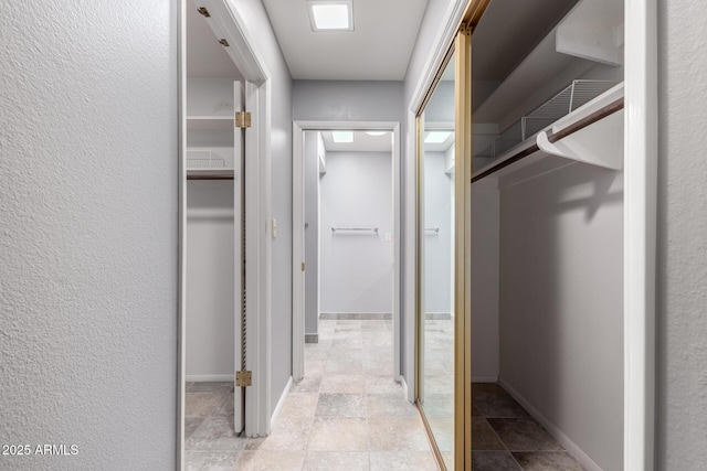 corridor with a textured wall and baseboards