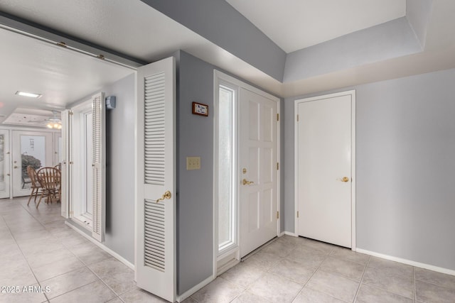 foyer entrance featuring baseboards and light tile patterned floors