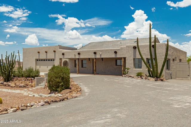 5736 E Singletree St, Apache Junction, AZ 85119 - pueblo revival-style home featuring a garage, stucco siding, driveway, and a gate