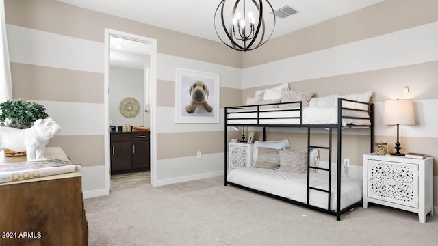 bedroom featuring a chandelier, ensuite bathroom, and light colored carpet