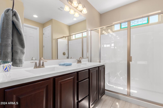 bathroom with tile patterned floors, a shower with door, and vanity