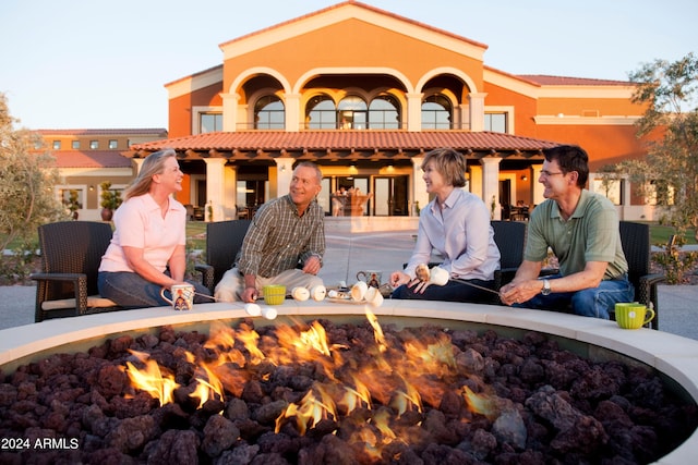 rear view of property featuring a fire pit