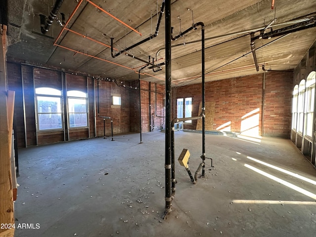 miscellaneous room featuring brick wall and concrete floors