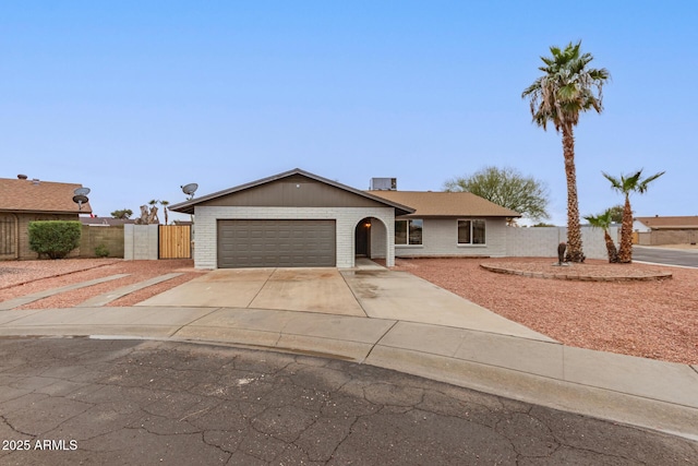 single story home featuring an attached garage, fence, concrete driveway, and brick siding