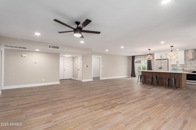 unfurnished living room featuring light wood-type flooring, visible vents, and recessed lighting