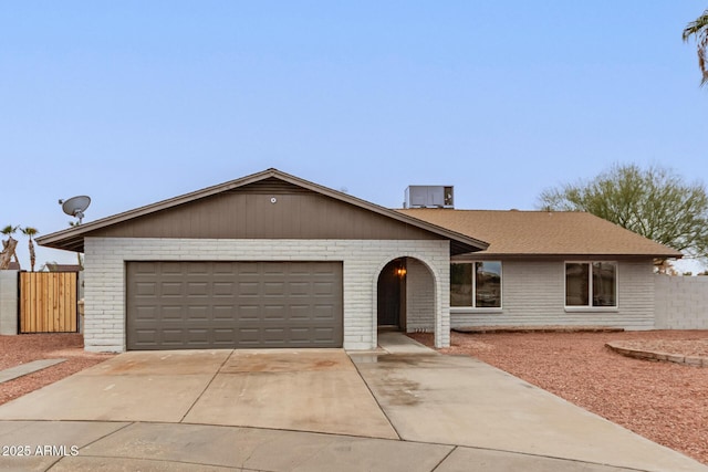 single story home with driveway, a garage, fence, cooling unit, and brick siding