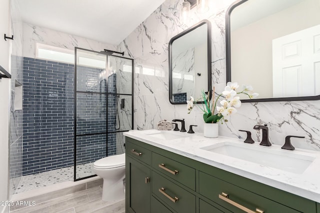 full bathroom with a tile shower, a sink, tile walls, and toilet