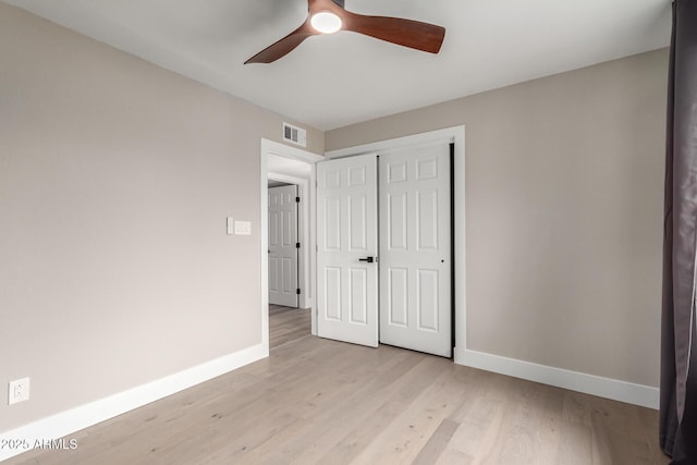 unfurnished bedroom with light wood-style floors, a closet, visible vents, and baseboards