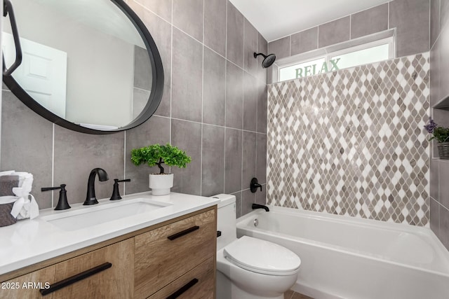 bathroom with toilet, vanity, tile walls, and shower / bathing tub combination