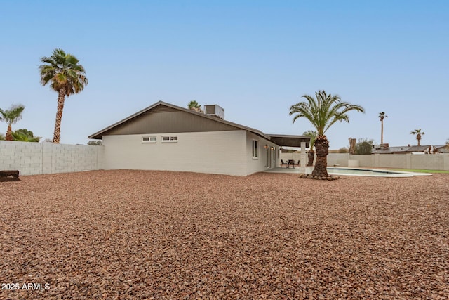 back of house featuring a fenced in pool, a fenced backyard, and a patio