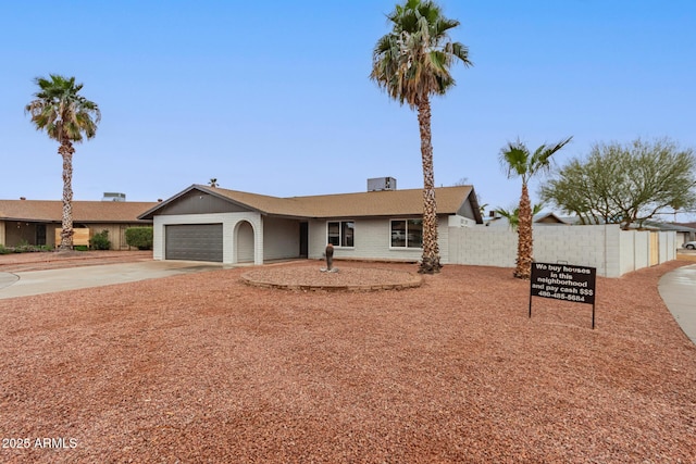 single story home featuring concrete driveway, fence, and an attached garage