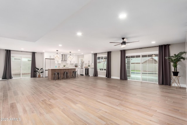 unfurnished living room featuring ceiling fan, light wood-style flooring, and recessed lighting