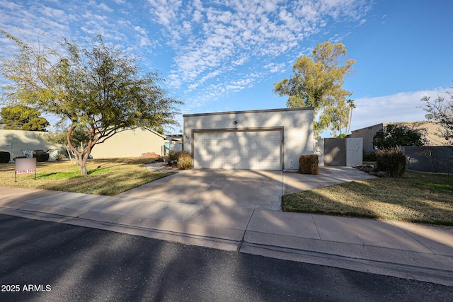 contemporary house with a garage, fence, driveway, stucco siding, and a front yard