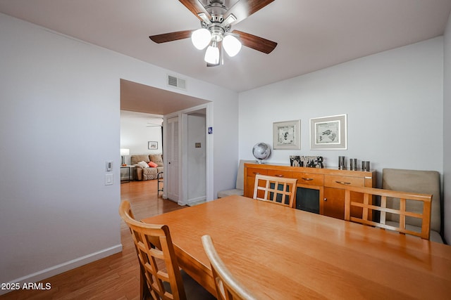 dining space with visible vents, ceiling fan, light wood-style flooring, and baseboards