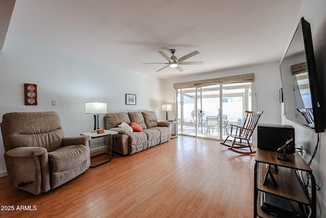 living room with a ceiling fan and light wood finished floors