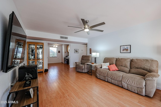 living area with light wood-type flooring, visible vents, and ceiling fan