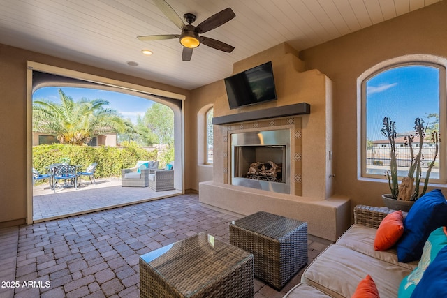 view of patio / terrace featuring an outdoor living space with a fireplace and ceiling fan