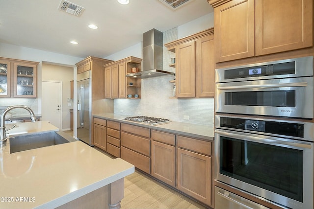 kitchen with visible vents, a sink, wall chimney range hood, appliances with stainless steel finishes, and open shelves