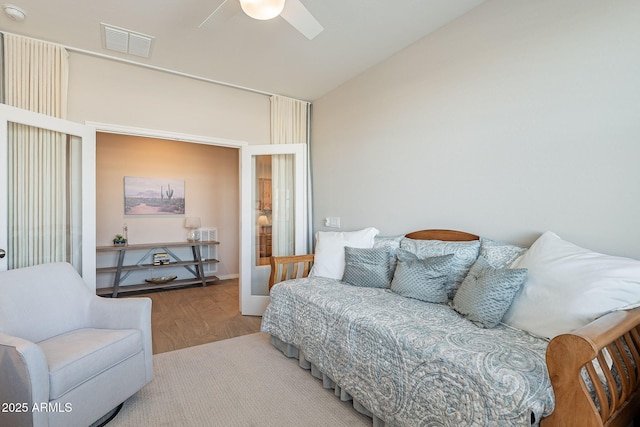 bedroom featuring visible vents, lofted ceiling, wood finished floors, and a ceiling fan