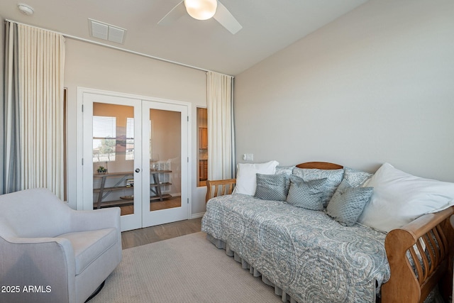 bedroom with visible vents, wood finished floors, french doors, lofted ceiling, and ceiling fan