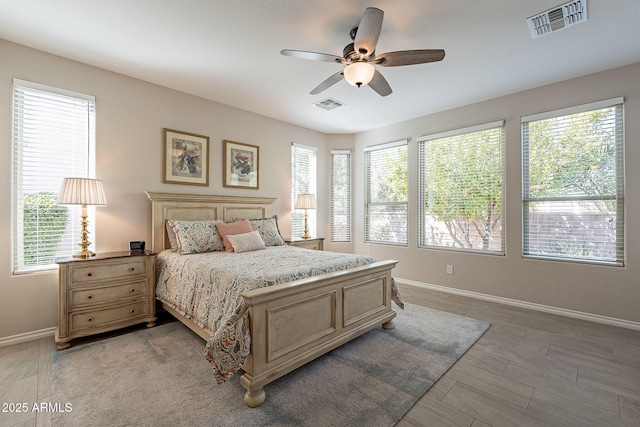 bedroom featuring visible vents, multiple windows, and baseboards