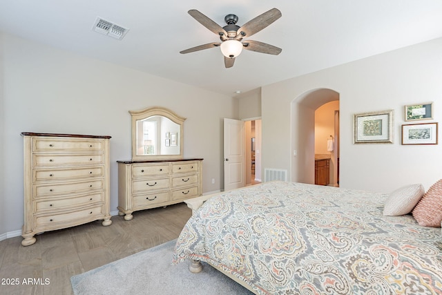 bedroom with a ceiling fan, arched walkways, visible vents, and baseboards