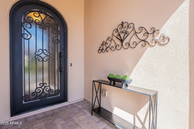 doorway to property featuring stucco siding