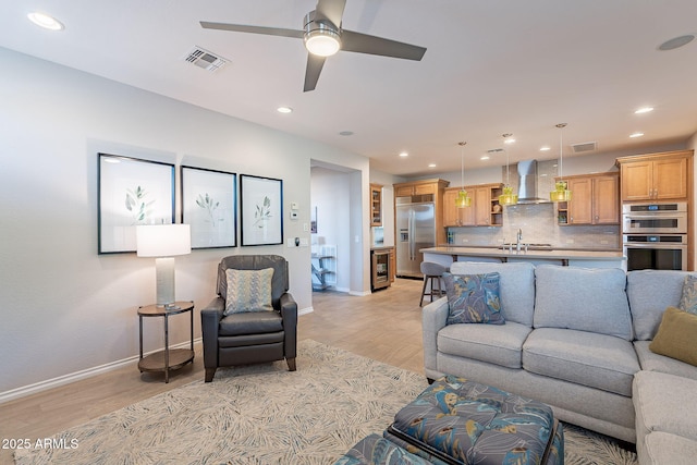 living area featuring light wood-type flooring, visible vents, baseboards, and recessed lighting