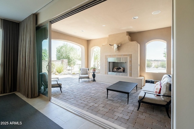 living area with recessed lighting and an outdoor fireplace