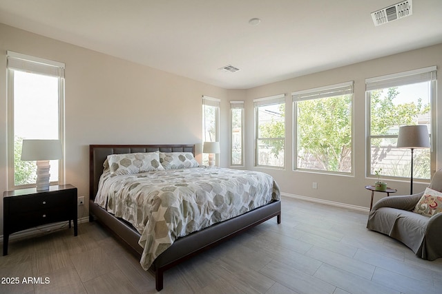 bedroom with visible vents, multiple windows, and baseboards