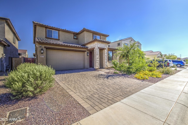 5621 W Chuck Box Rd, Laveen, AZ 85339 - mediterranean / spanish-style house featuring stucco siding, decorative driveway, a tile roof, a garage, and stone siding