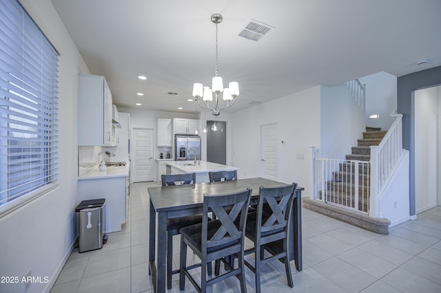 5621 W Chuck Box Rd, Laveen, AZ 85339 - kitchen featuring a center island with sink, a chandelier, stainless steel fridge with ice dispenser, light countertops, and white cabinetry