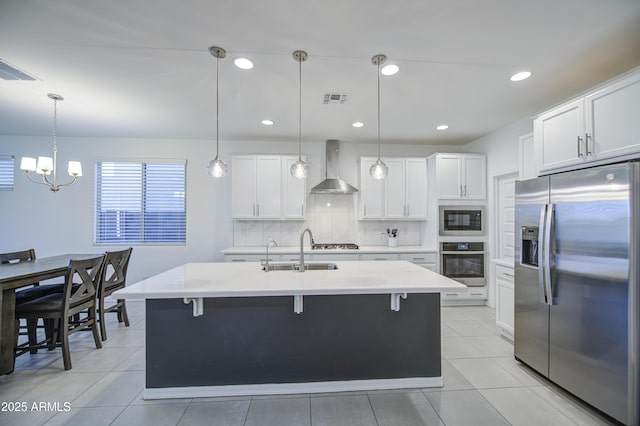 5621 W Chuck Box Rd, Laveen, AZ 85339 - kitchen featuring appliances with stainless steel finishes, wall chimney exhaust hood, light countertops, backsplash, and a chandelier