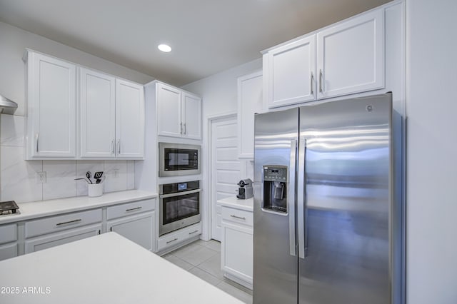 5621 W Chuck Box Rd, Laveen, AZ 85339 - kitchen featuring appliances with stainless steel finishes, backsplash, light countertops, white cabinetry, and light tile patterned floors