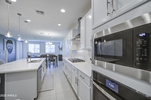 5621 W Chuck Box Rd, Laveen, AZ 85339 - kitchen featuring wall chimney range hood, light countertops, appliances with stainless steel finishes, tasteful backsplash, and recessed lighting
