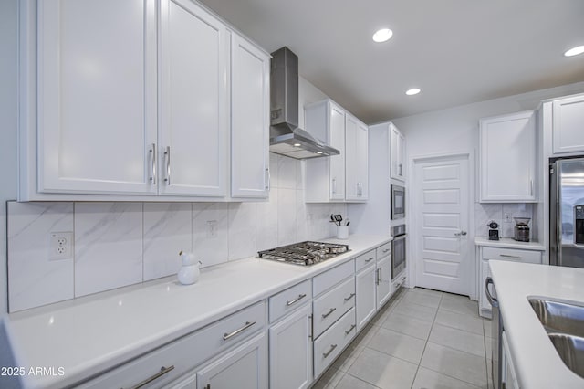 5621 W Chuck Box Rd, Laveen, AZ 85339 - kitchen featuring wall chimney exhaust hood, appliances with stainless steel finishes, backsplash, white cabinets, and light countertops