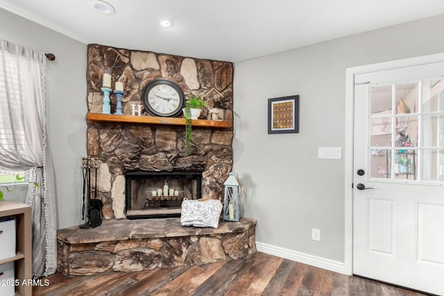 interior space with wood-type flooring and a stone fireplace