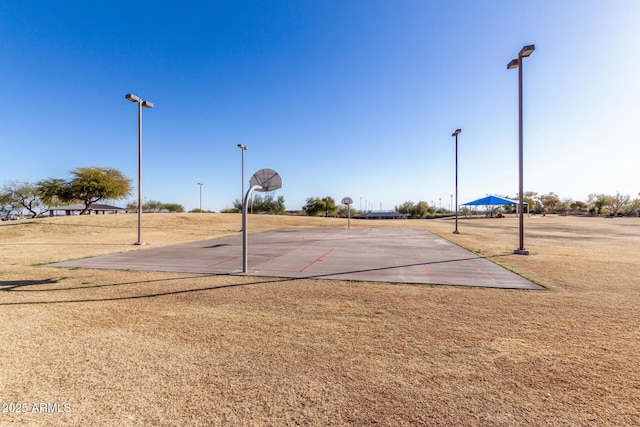 view of sport court with a lawn