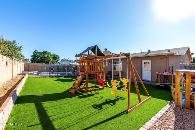 view of playground with a trampoline, a fenced in pool, and a yard