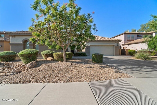view of front of home featuring an attached garage, driveway, a tile roof, and stucco siding