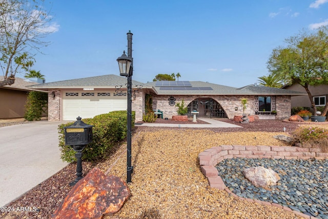 ranch-style house featuring solar panels and a garage