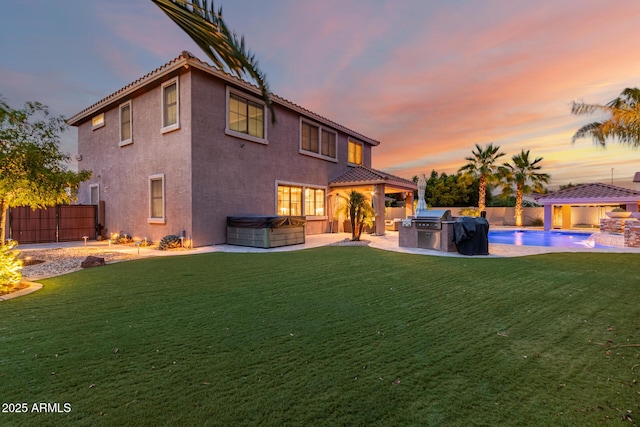 1179 E Regent Dr, Gilbert, AZ 85298 - back of property at dusk with a hot tub, stucco siding, area for grilling, and a patio