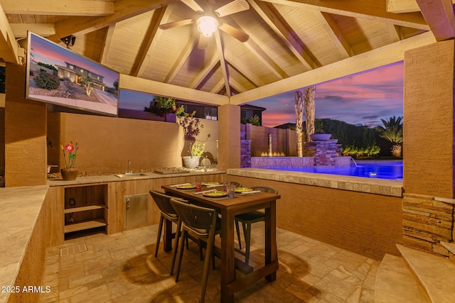 1179 E Regent Dr, Gilbert, AZ 85298 - patio terrace at dusk with a gazebo, an outdoor kitchen, fence, ceiling fan, and a sink