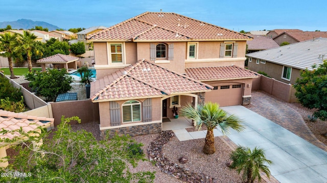 1179 E Regent Dr, Gilbert, AZ 85298 - mediterranean / spanish-style house featuring stucco siding, driveway, a fenced backyard, and stone siding