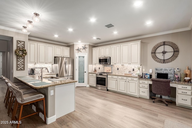 1179 E Regent Dr, Gilbert, AZ 85298 - kitchen featuring appliances with stainless steel finishes, a peninsula, tasteful backsplash, a desk, and ornamental molding